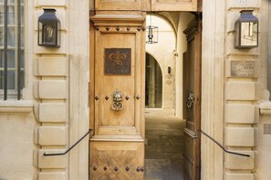 A wooden door with a plaque, a metal knocker, and a small window. - La Maison d'Uzes (Uzès)