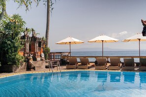 Piscine extérieure, parasols de plage, chaises longues