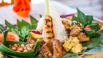 A plate of food with rice, grilled meat, and various side dishes.
