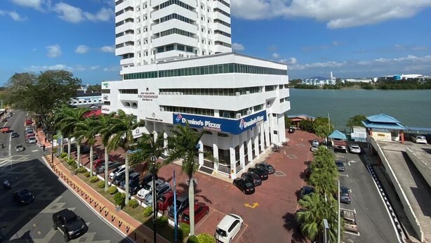 A multi-story hotel with a modern design, featuring a prominent Domino's Pizza sign on the ground floor. - Muar Traders Hotel (Muar)
