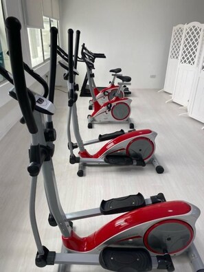 A row of stationary bikes in a room with a light-colored floor and white walls. - Muar Traders Hotel (Muar)