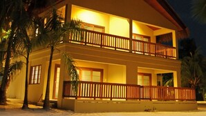Un bâtiment à deux étages doté d’un balcon, entouré de palmiers.