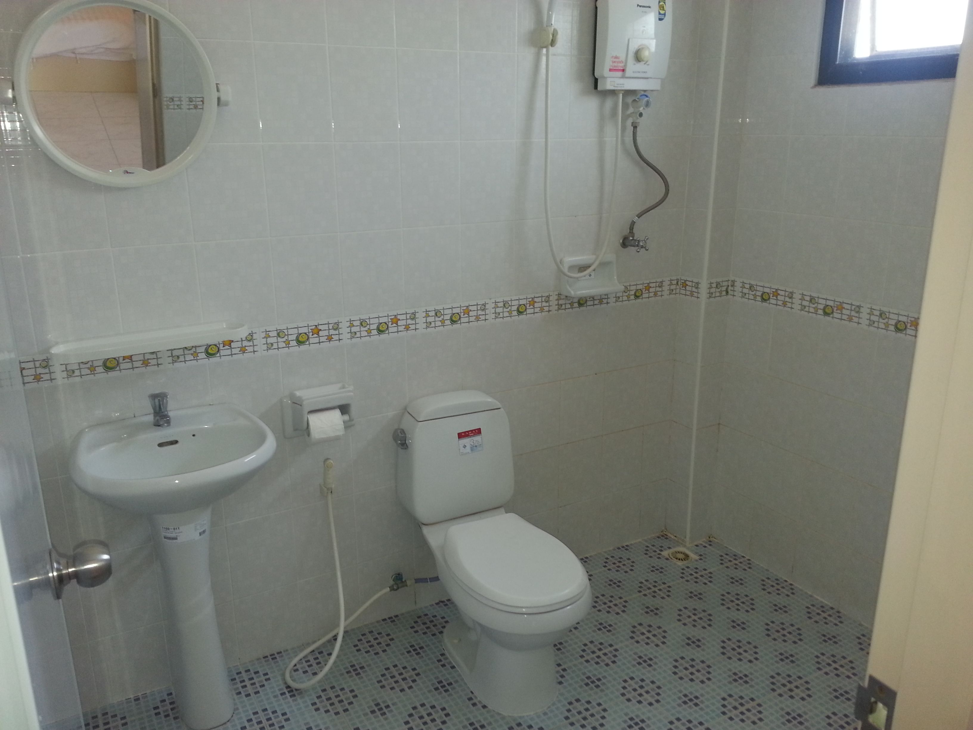 Et badeværelse med toilet, håndvask og spejl.
