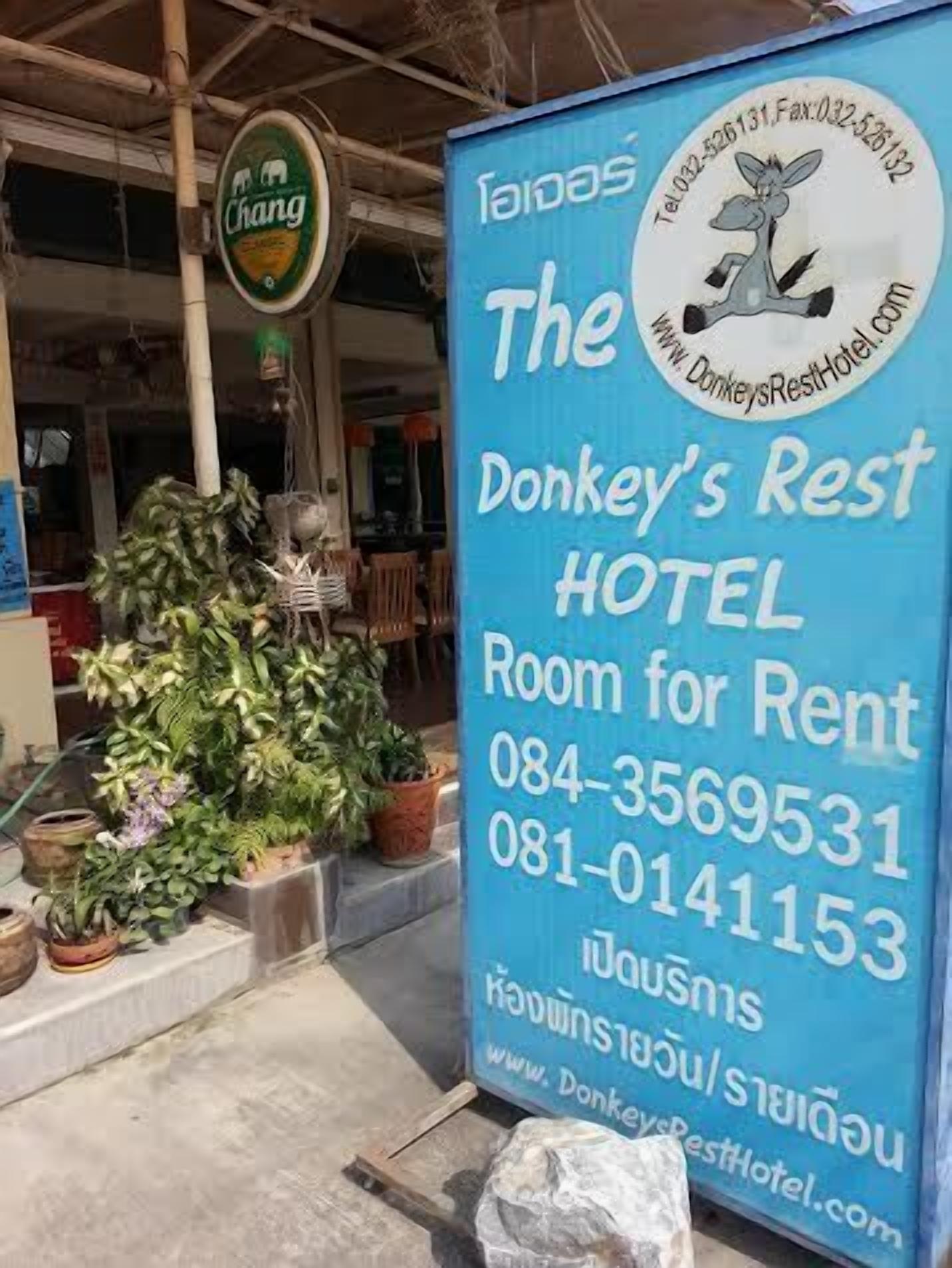 A blue sign for Donkey's Rest Hotel with contact numbers and a website URL.