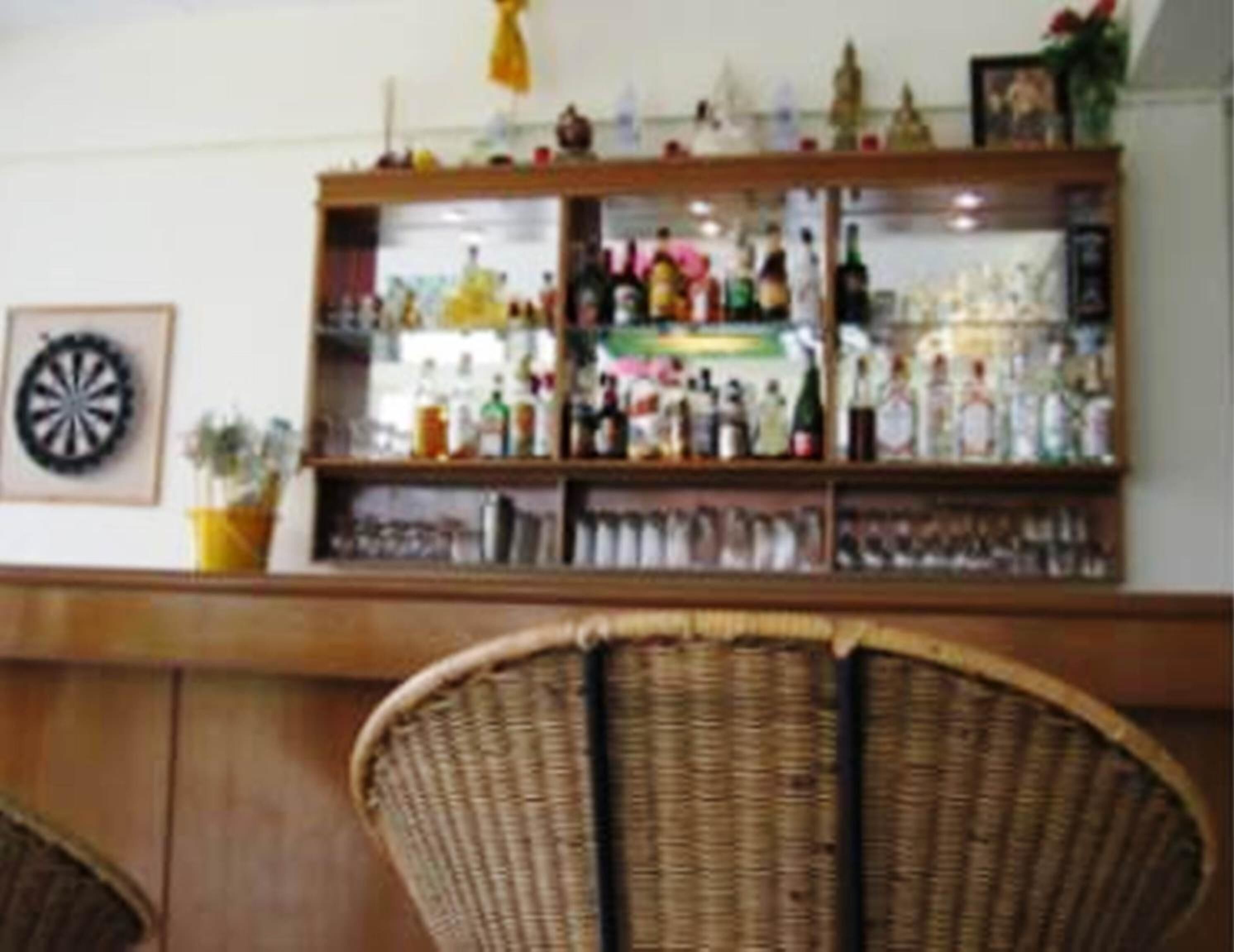 A bar area with shelves stocked with various bottles and glasses.