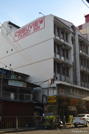 Un edifici de diversos pisos amb un rètol que diu 'Cebuview Tourist Inn' al pis superior.