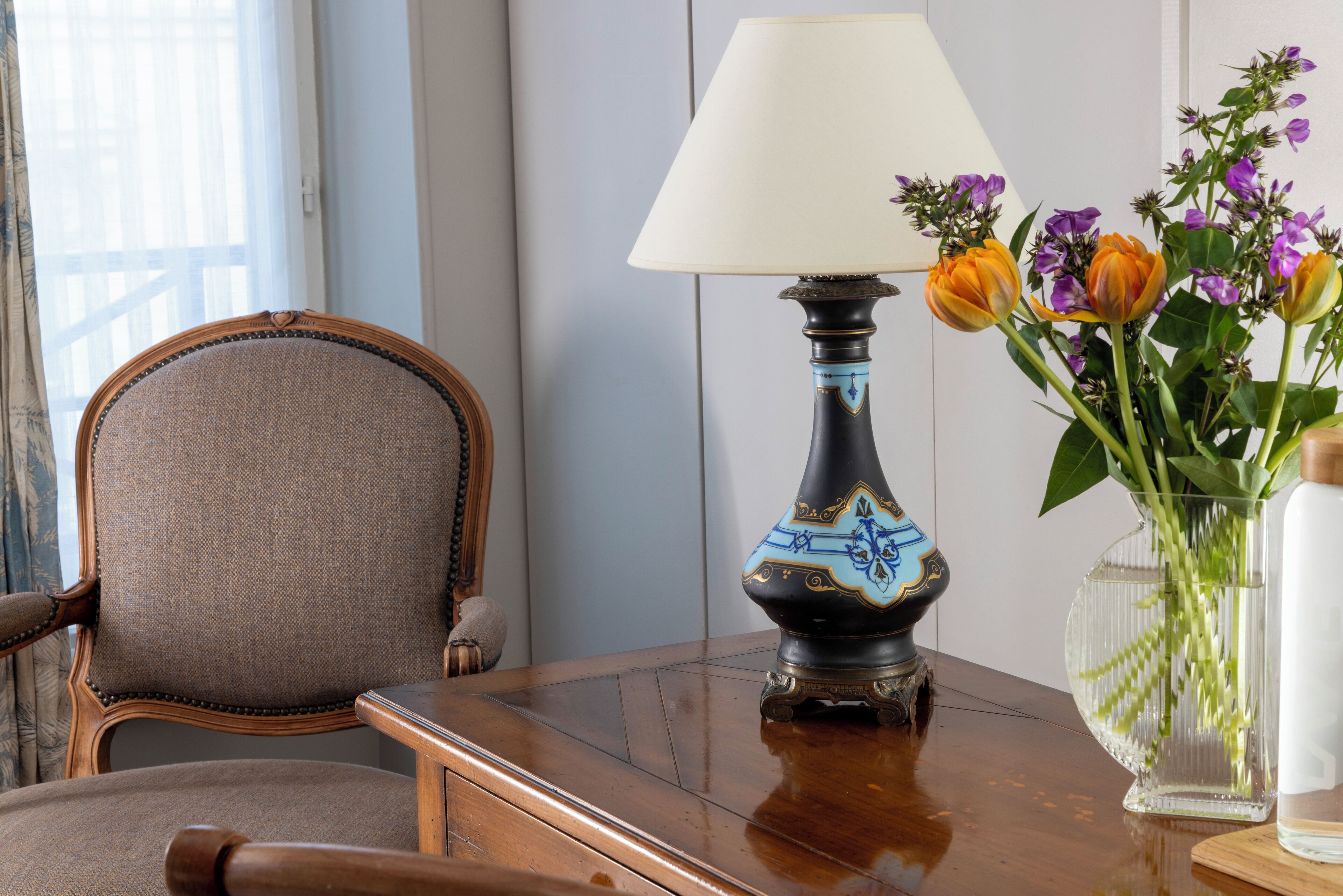 Et træbord med en lampe og en blomstervase.