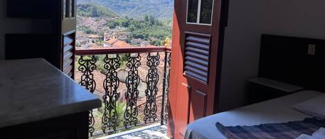 A balcony with a view of a town and mountains.