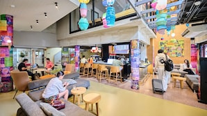 A spacious indoor area with seating, a bar, and colorful hanging decorations.