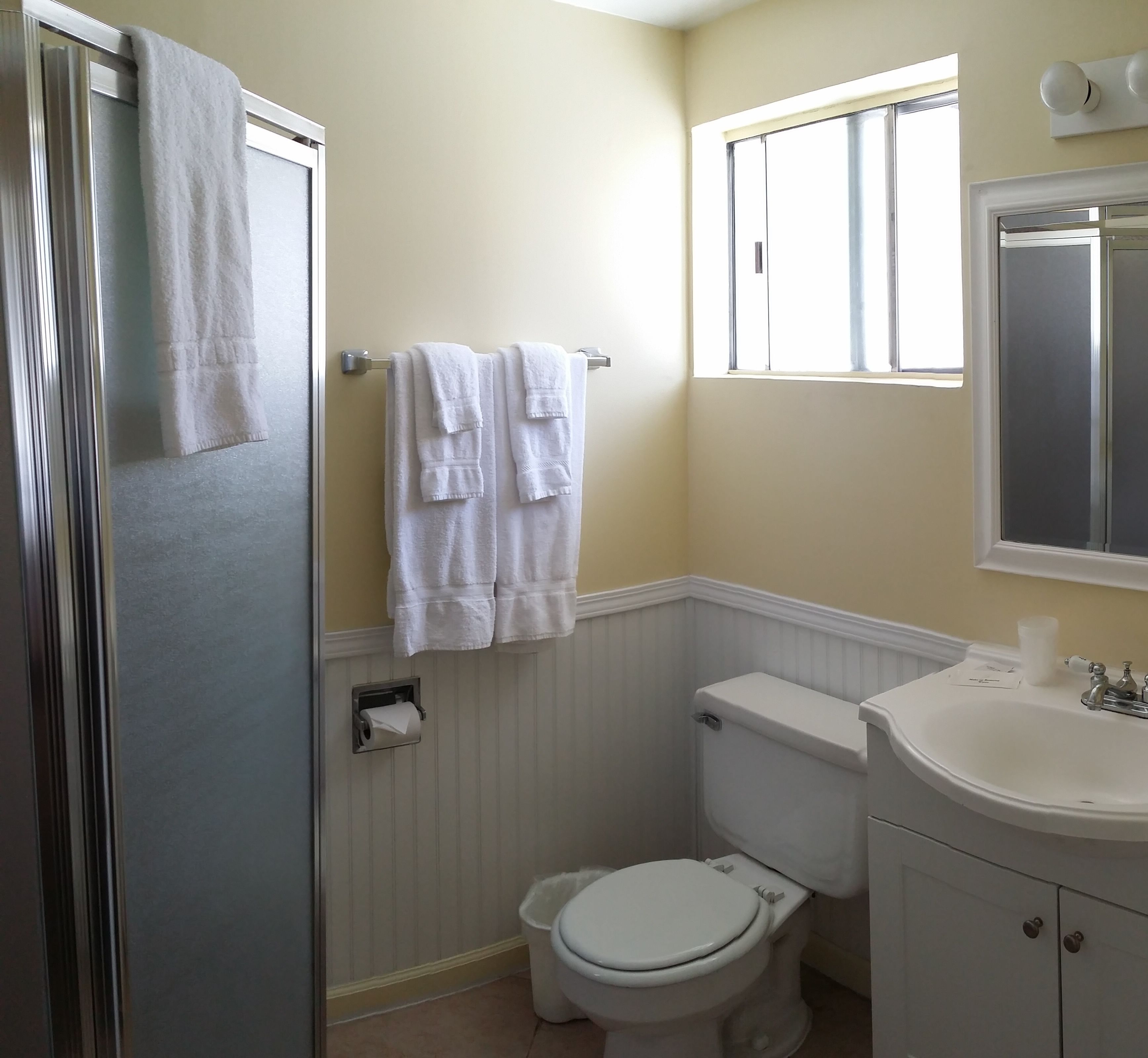 Une salle de bain équipée de toilettes, d’un lavabo et d’un porte-serviettes.