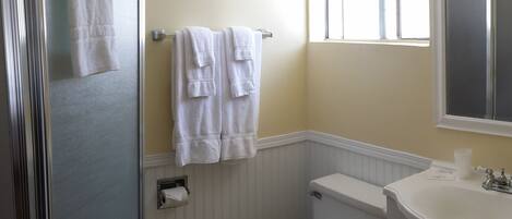 Une salle de bain équipée de toilettes, d’un lavabo et d’un porte-serviettes.