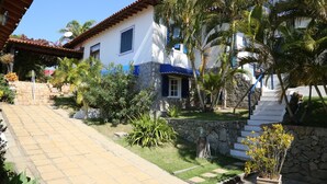 Una casa blanca con detalles azules, una escalera de piedra y un camino empedrado.