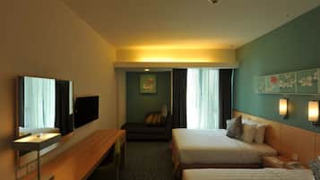 A hotel room with two beds, a desk, a flat-screen TV, and a painting on the wall.