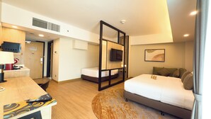 Une chambre d’hôtel avec un lit, un bureau et une chaise, une télévision et une porte de salle de bain.