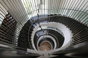 A spiral staircase with a modern design, featuring glass railings and metal balustrades. - The Everly Putrajaya (Putrajaya)
