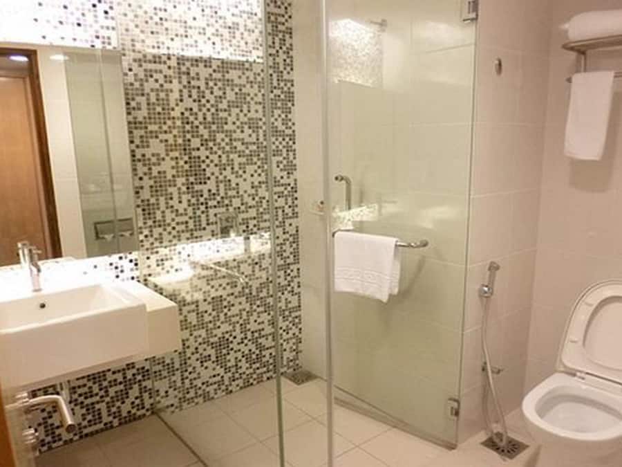 A modern bathroom with a glass shower enclosure, a white sink, and a toilet.