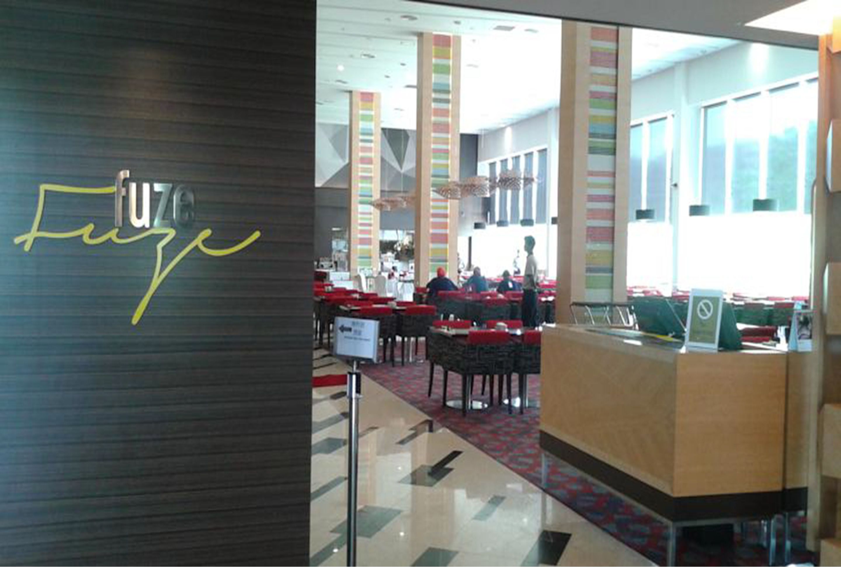 A modern interior with a reception desk, multiple tables, and chairs.