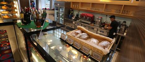 A bakery display with various baked goods and a coffee station.
