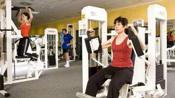 A gym with various exercise machines, including a leg press and a chest press machine.