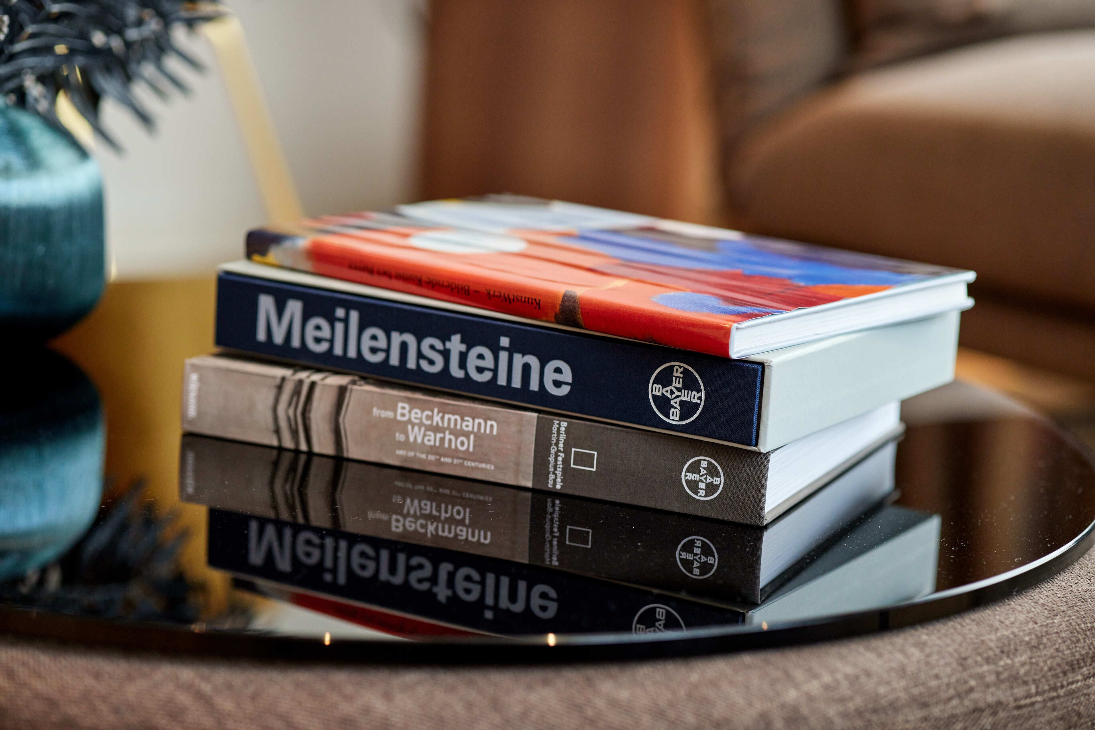 A stack of books on a reflective surface.