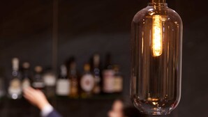 A bar area with a person reaching for a bottle. - Kasino Hotel (Leverkusen)