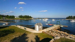 A coastal marina with boats, a small dock, and a grassy area. - Newagen Seaside Inn (Southport)