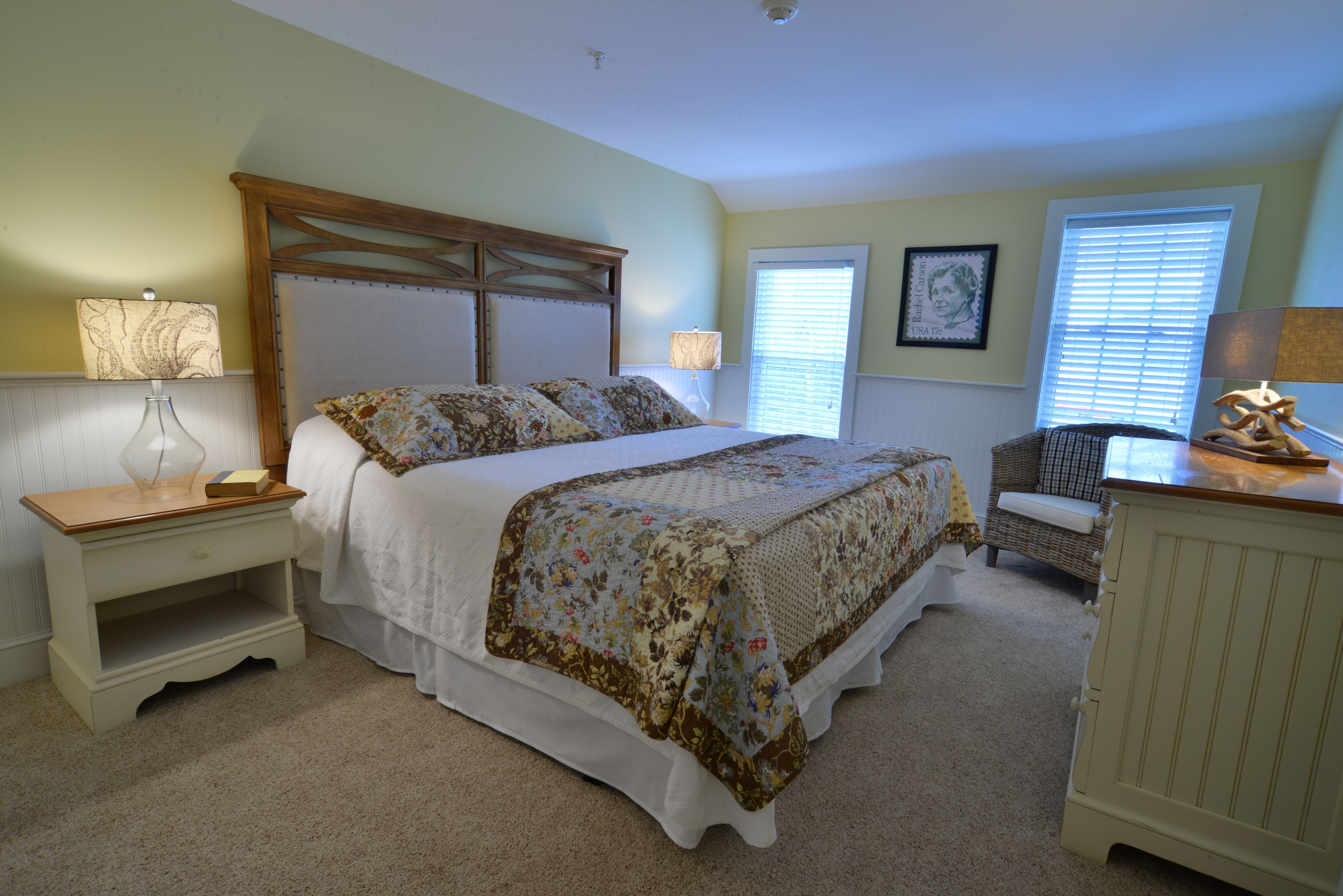 A bedroom with a bed, nightstands, a chair, and a dresser.