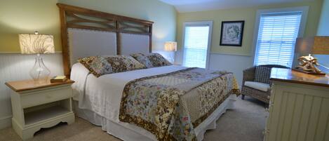 A bedroom with a bed, nightstands, a chair, and a dresser.