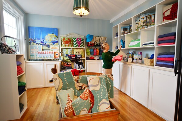 A room with white cabinets, a wooden chest, and shelves with various items including bags and folded clothes. - Newagen Seaside Inn (Southport)