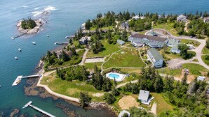 An aerial view of a coastal property with a large house, a swimming pool, and a dock. - Newagen Seaside Inn (Southport)