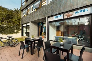Un hostal con mesas al aire libre y una bicicleta estacionada afuera.