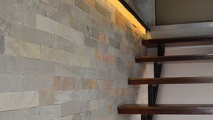 Un escalier avec un mur en pierre et des marches en bois.