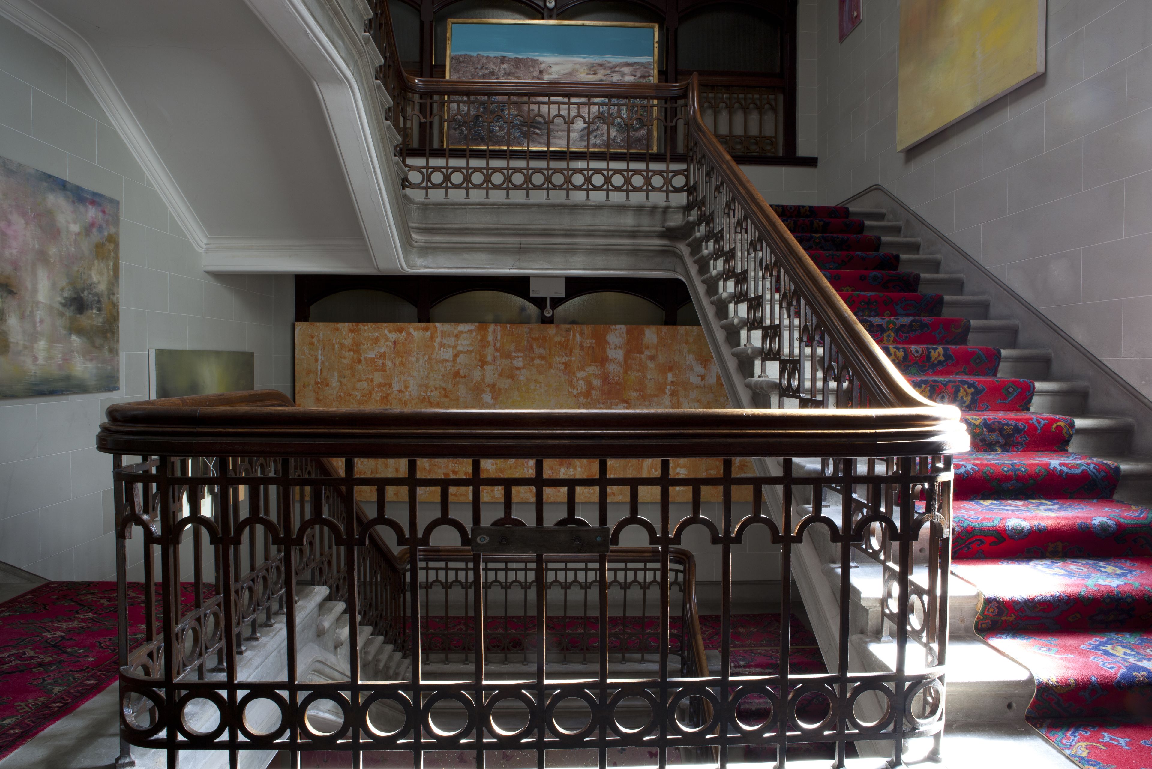 A grand staircase with ornate metal railings and patterned carpeted steps.