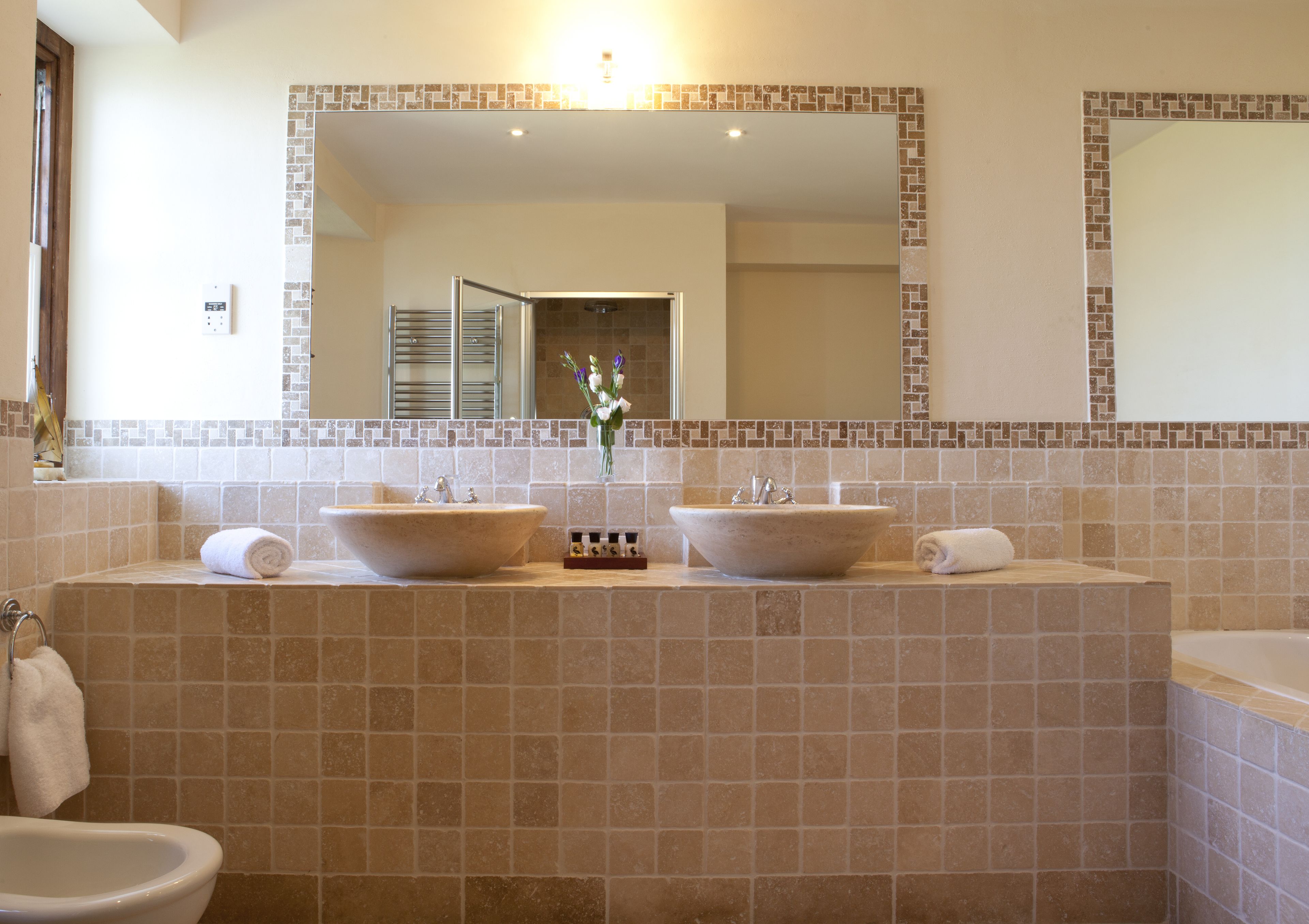 A bathroom with two vessel sinks, a bathtub, and a toilet.