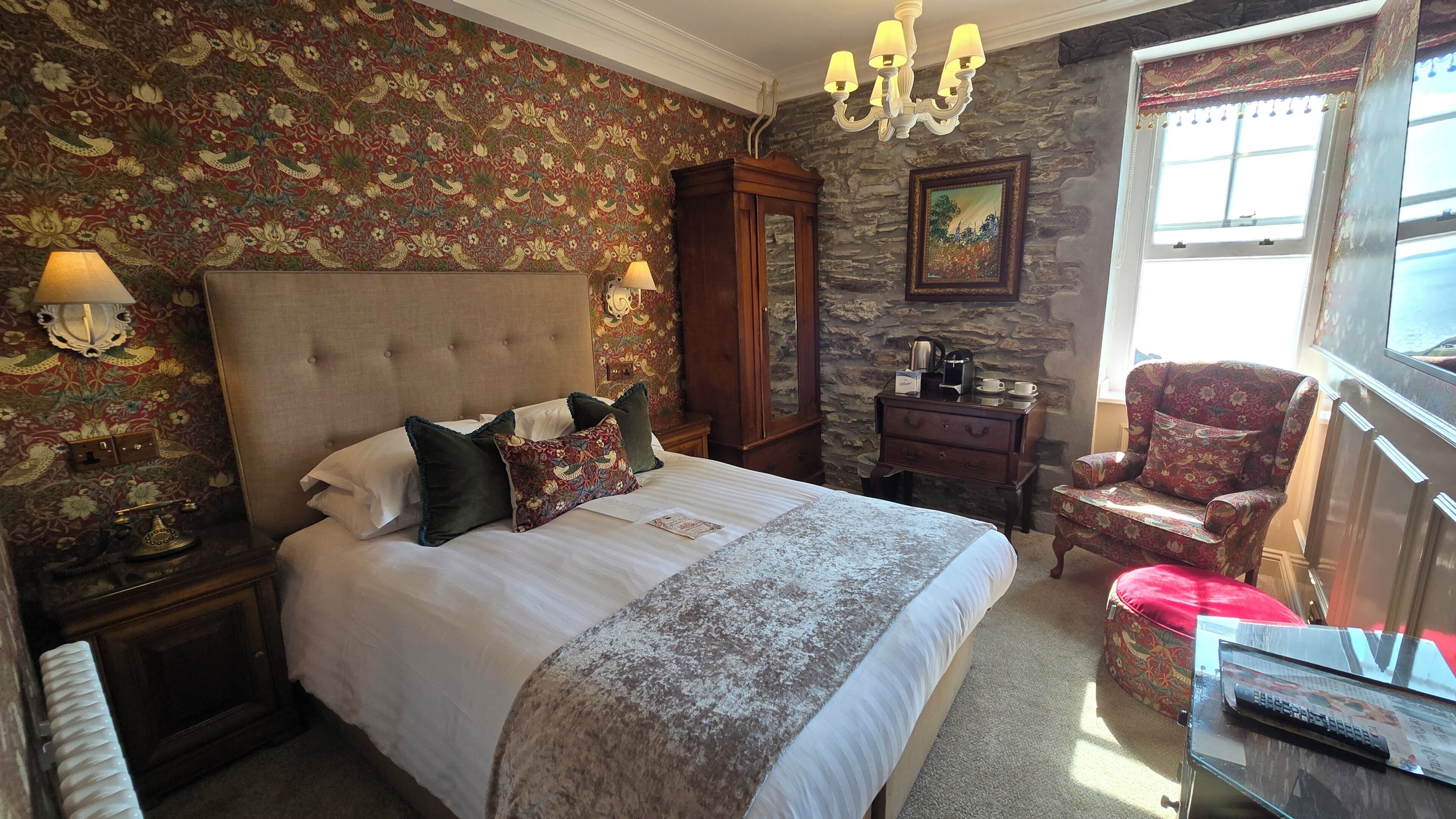 Un dormitorio con una cama grande, un aparador, una silla y un cuadro en la pared.