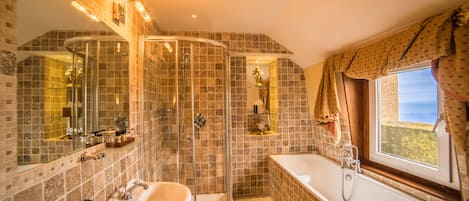 Un baño con ducha envuelta en cristal, una bañera y un lavabo.