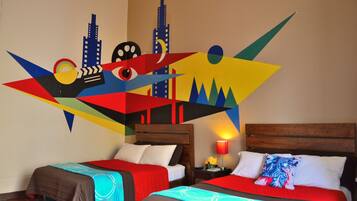 A hotel room with two beds, wooden headboards, and a colorful abstract wall art.