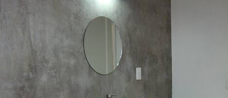 Un baño con inodoro, lavamanos y espejo.