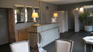 A room with a large mirror, a dresser, two lamps, and a potted plant. - Hotel de la Mer (Pleneuf-Val-Andre)
