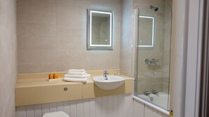 A bathroom with a toilet, sink, and glass-enclosed shower. - Charlemont Arms Hotel (Armagh)