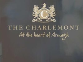 Um logotipo com um brasão e o texto "THE CHARLEMONT No coração de Armagh".