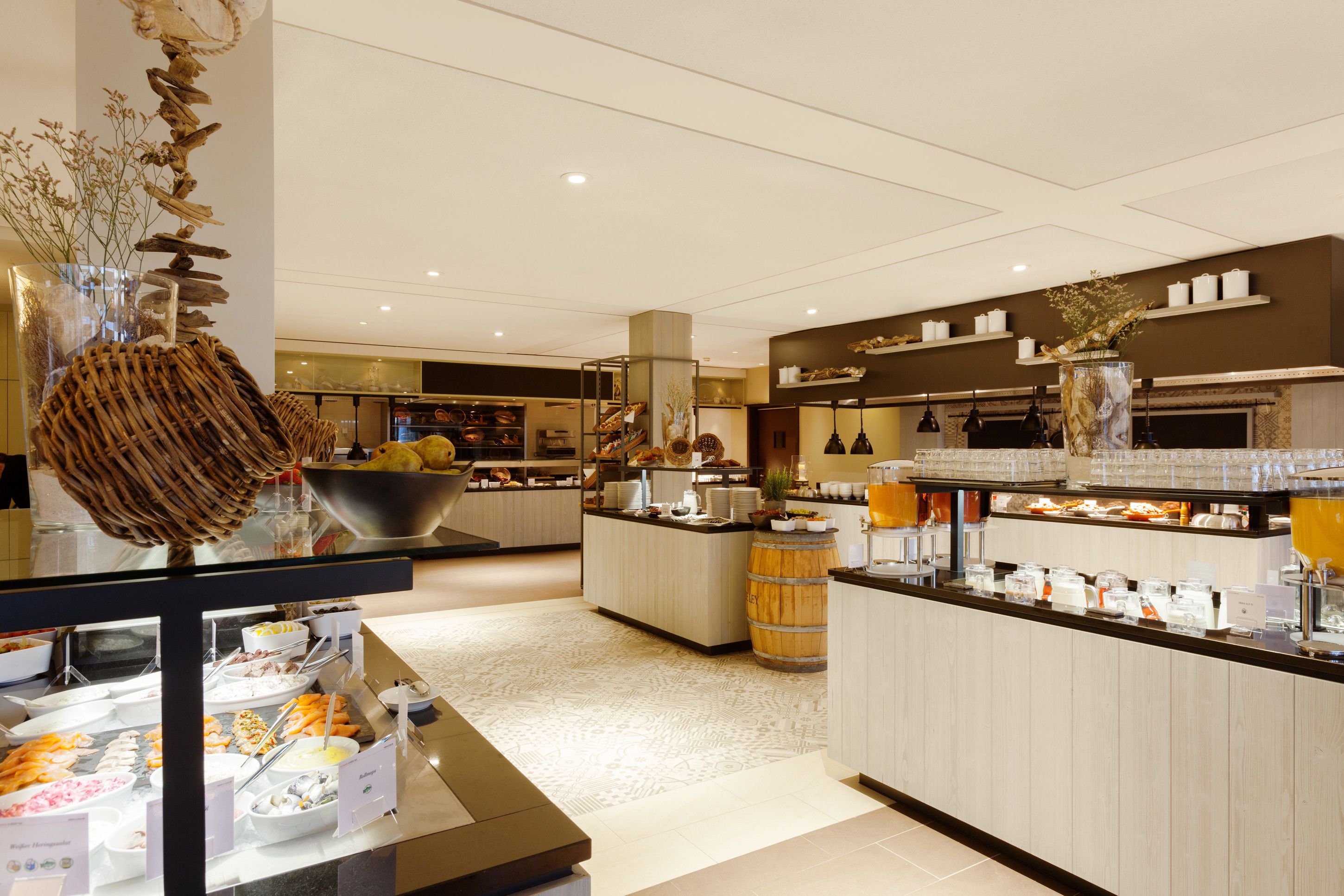 A buffet area with various food stations, a central island with a decorative sculpture, and a counter with beverages.