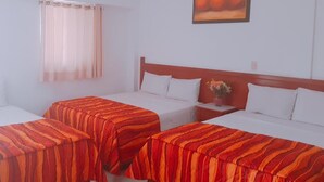 A hotel room with two single beds, a wooden headboard, a nightstand with a vase of flowers, and a painting on the wall. - Hotel Hacienda de Zapata (Jiutepec)