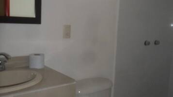 Un baño con inodoro, lavamanos y ventana.