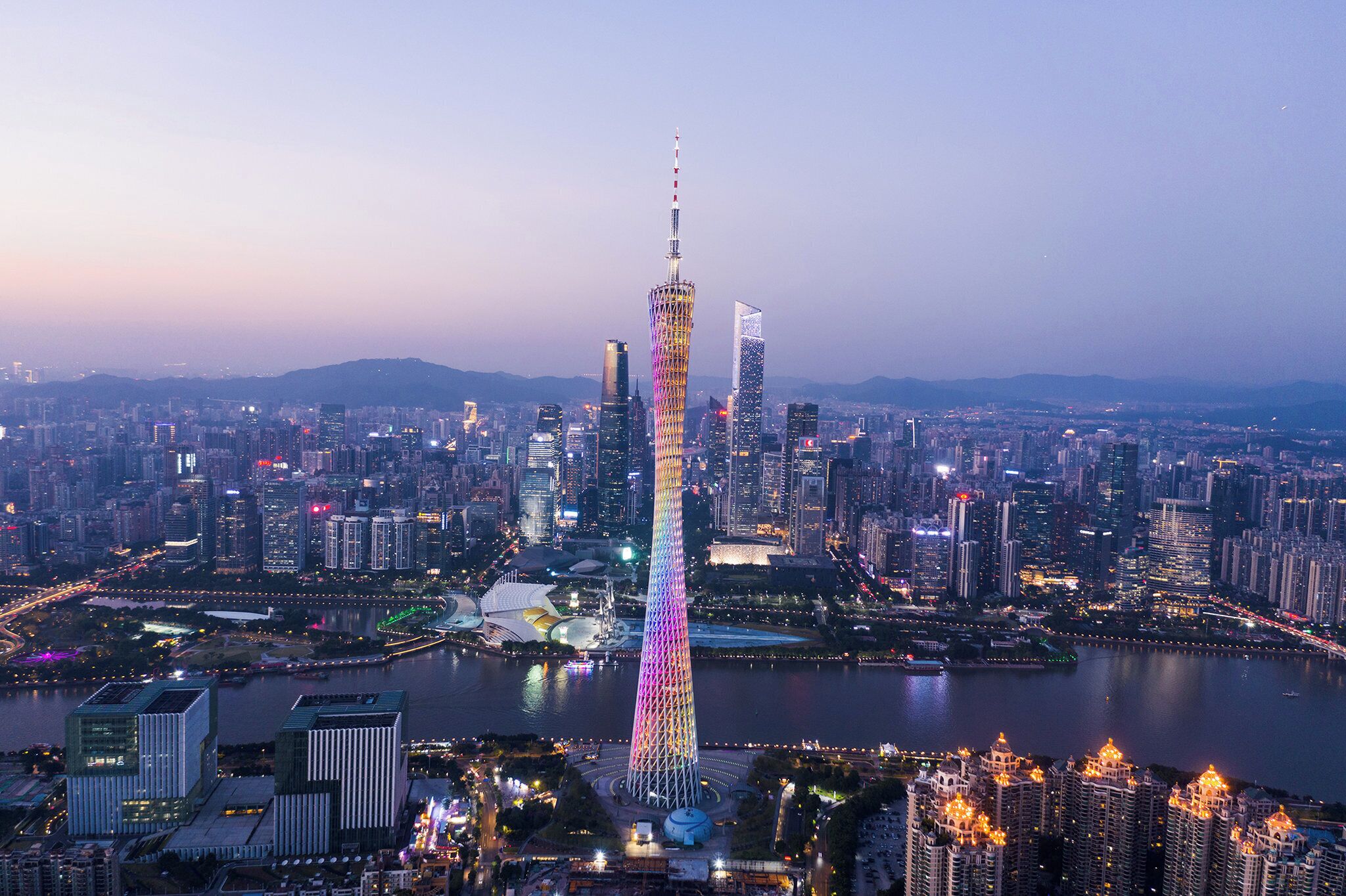 A cityscape with a prominent tower, surrounded by high-rise buildings and a body of water.