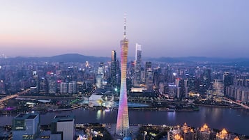 A cityscape with a prominent tower, surrounded by high-rise buildings and a body of water.
