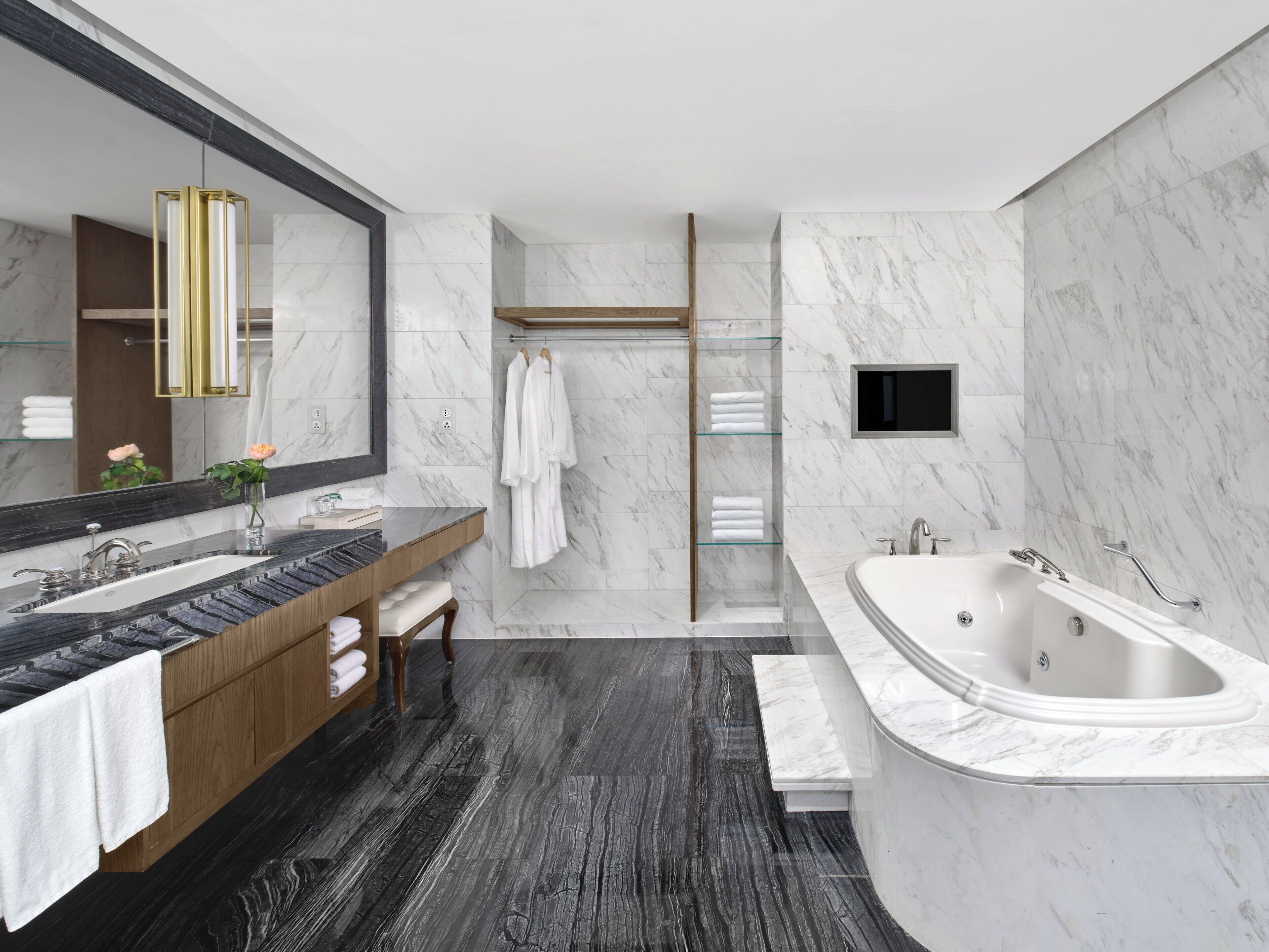 A modern bathroom with a dual sink vanity, a large bathtub, and a walk-in shower.