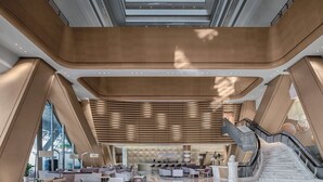 Un vestíbulo amplio con una zona de estar central, un bar y una escalera.