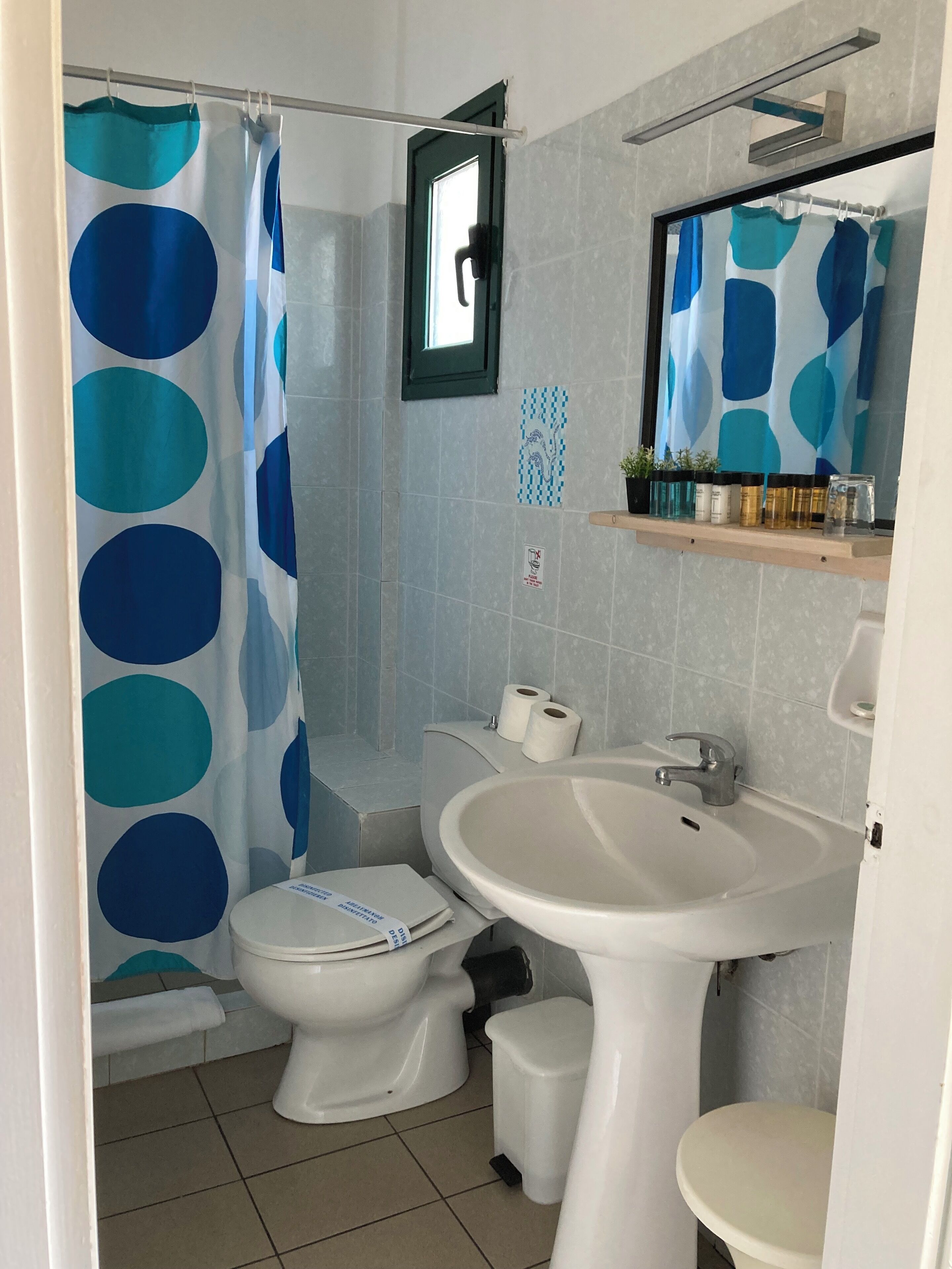 Une salle de bain avec des toilettes, un lavabo et un rideau de douche.
