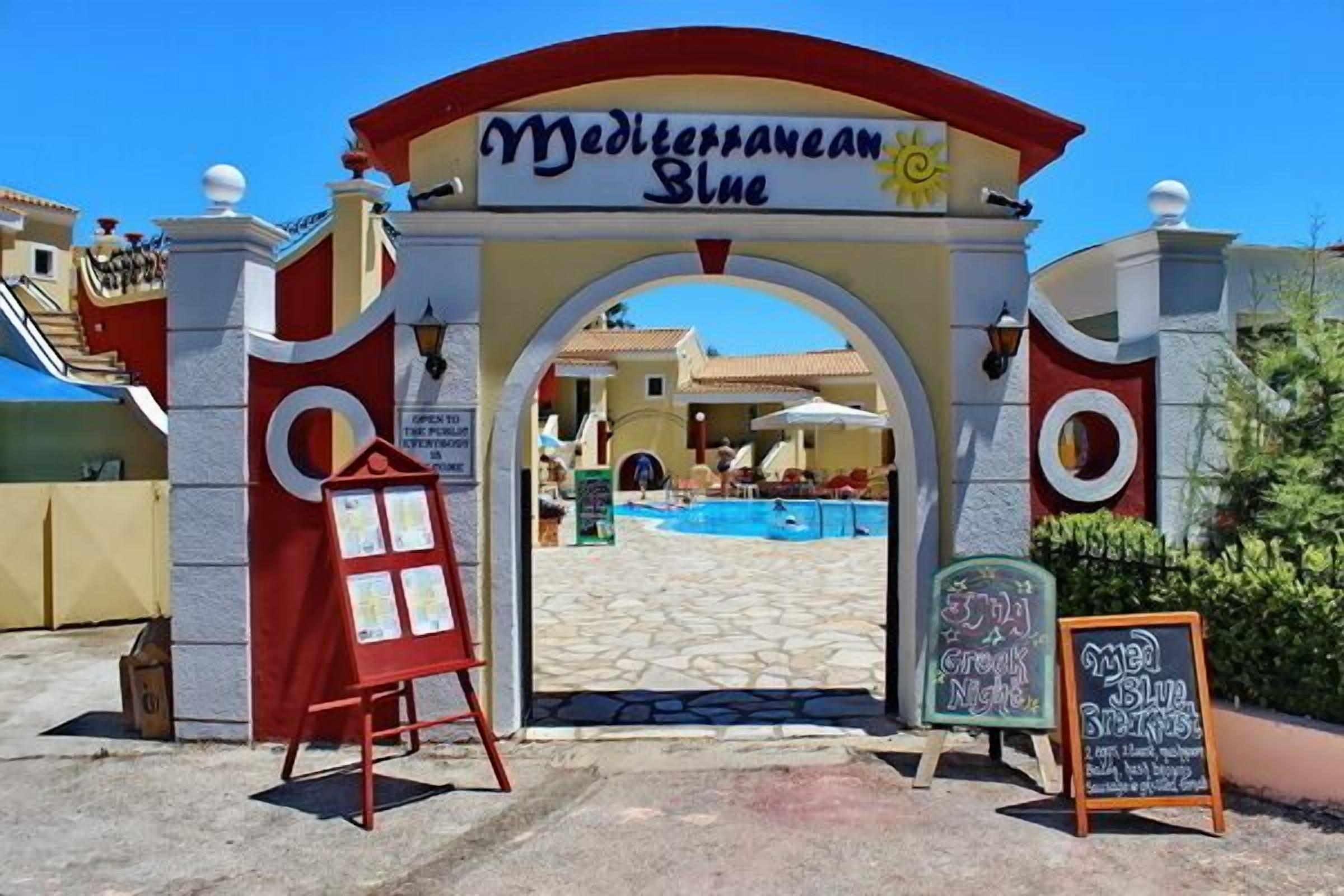 The entrance to Mediterranean Blue with a clear view of the pool area and a signboard advertising 'Crock Night'.